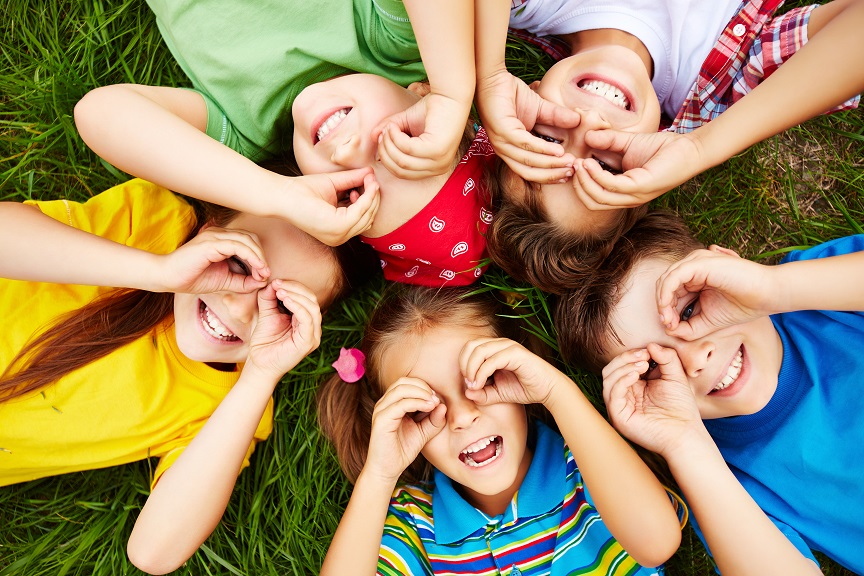 Group of cute children lying on grass